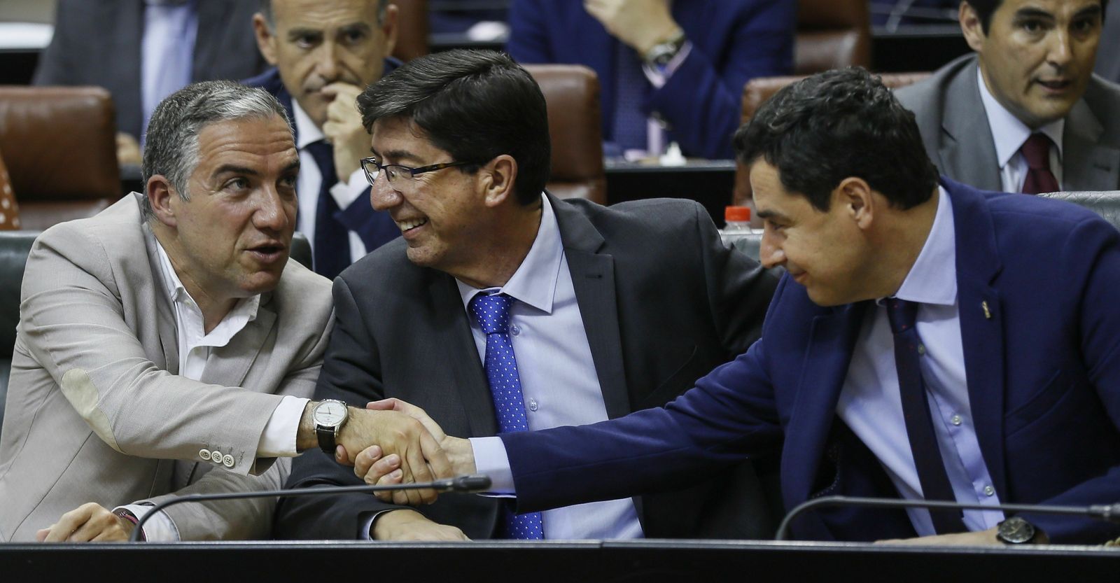 Juanma Moreno saluda a Elías Bendodo y Juan Marín, al inicio del pleno del Parlamento