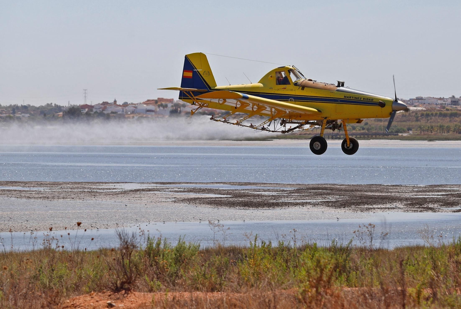Una avioneta fumiga en la zona de las marismas de Huelva.