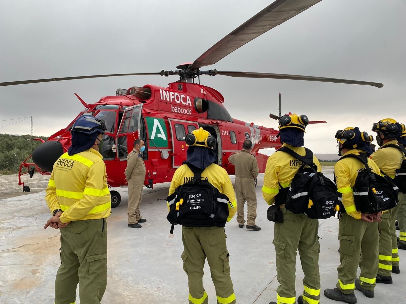 Imagen de archivo de un grupo de bomberos del Infoca y un helicóptero