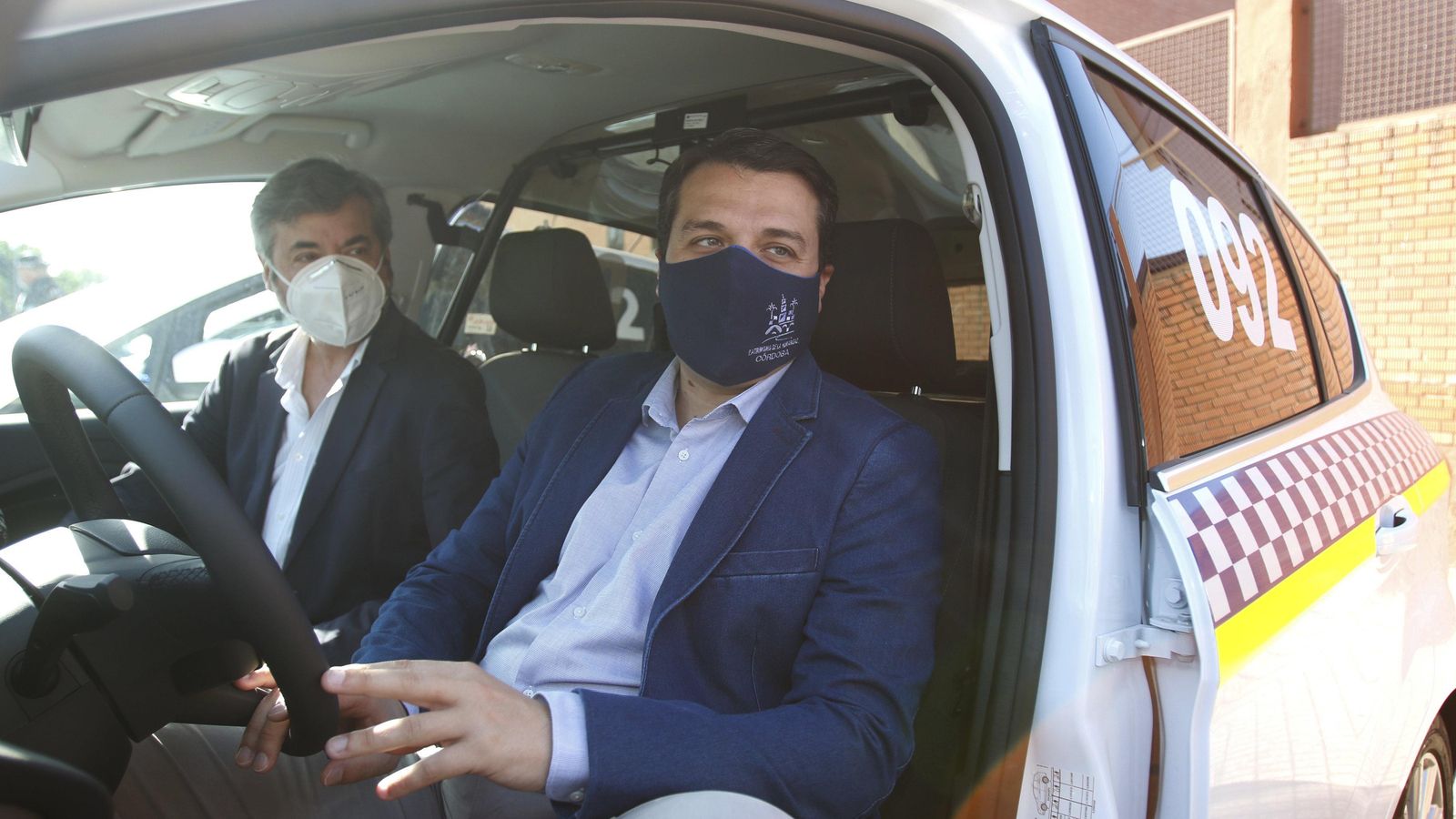 Miguel Ángel Torrico y José María Bellido en uno de los nuevos coches policiales.