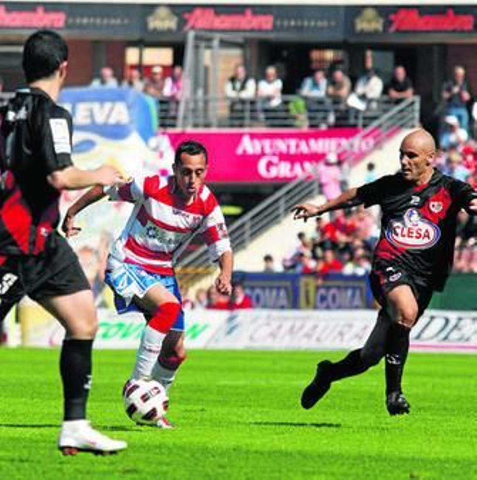 Orellana conduce el esférico entre Casado y el veterano Movilla.