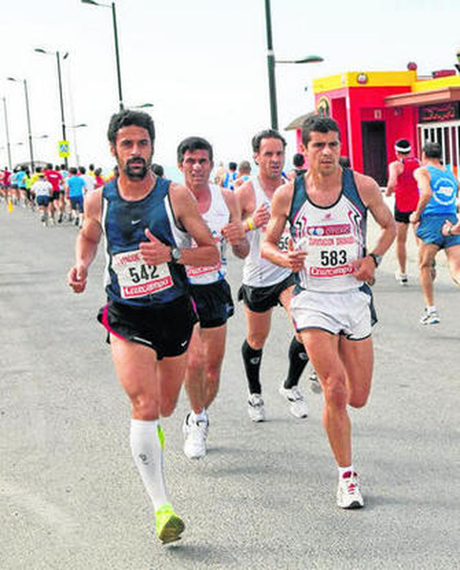 Los corredores a su paso por el paseo marítimo.