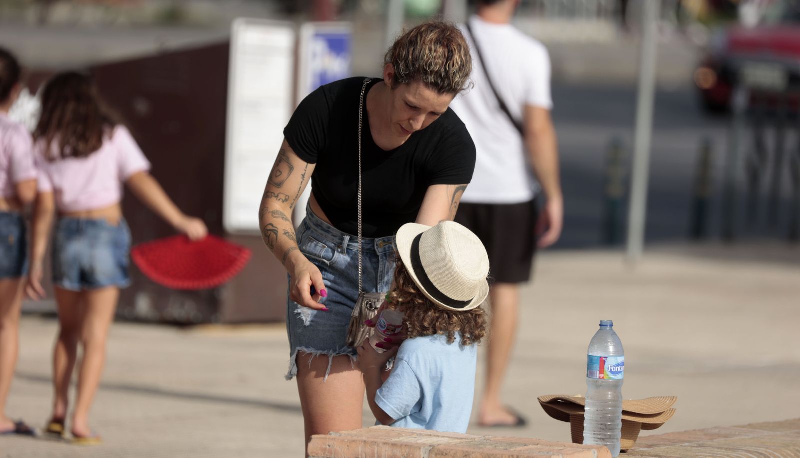 Una mujer le da de beber a su hijo