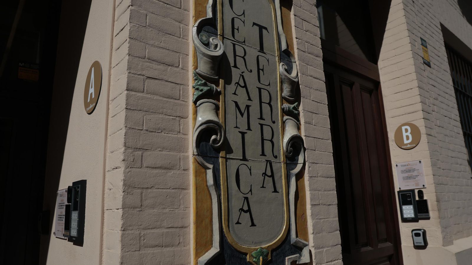 La entrada de dos apartamentos turísticos flanquean un azulejo de un antiguo negocio cerámico.