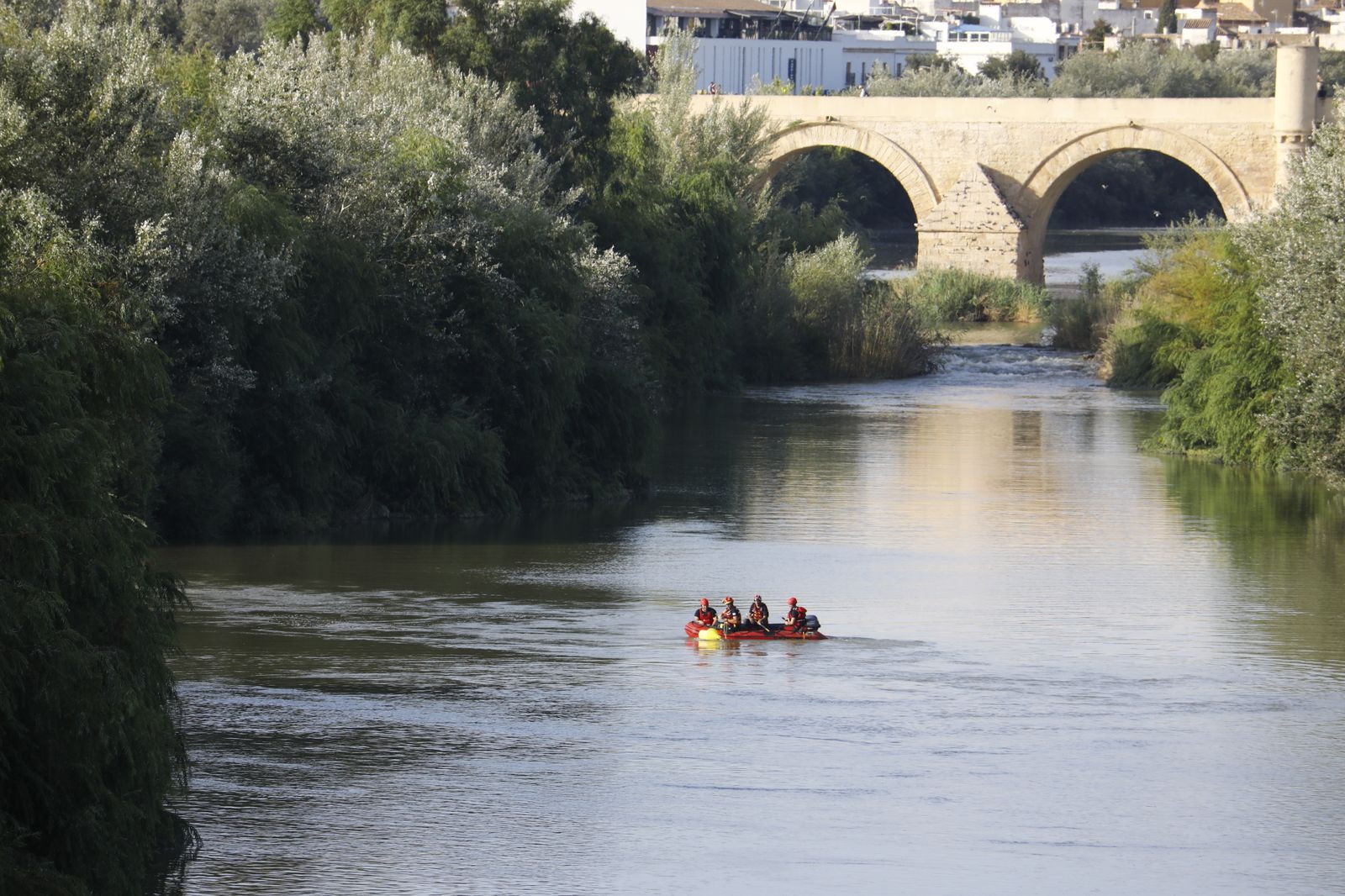 Los bomberos buscan al desaparecido en el Guadalquivir.
