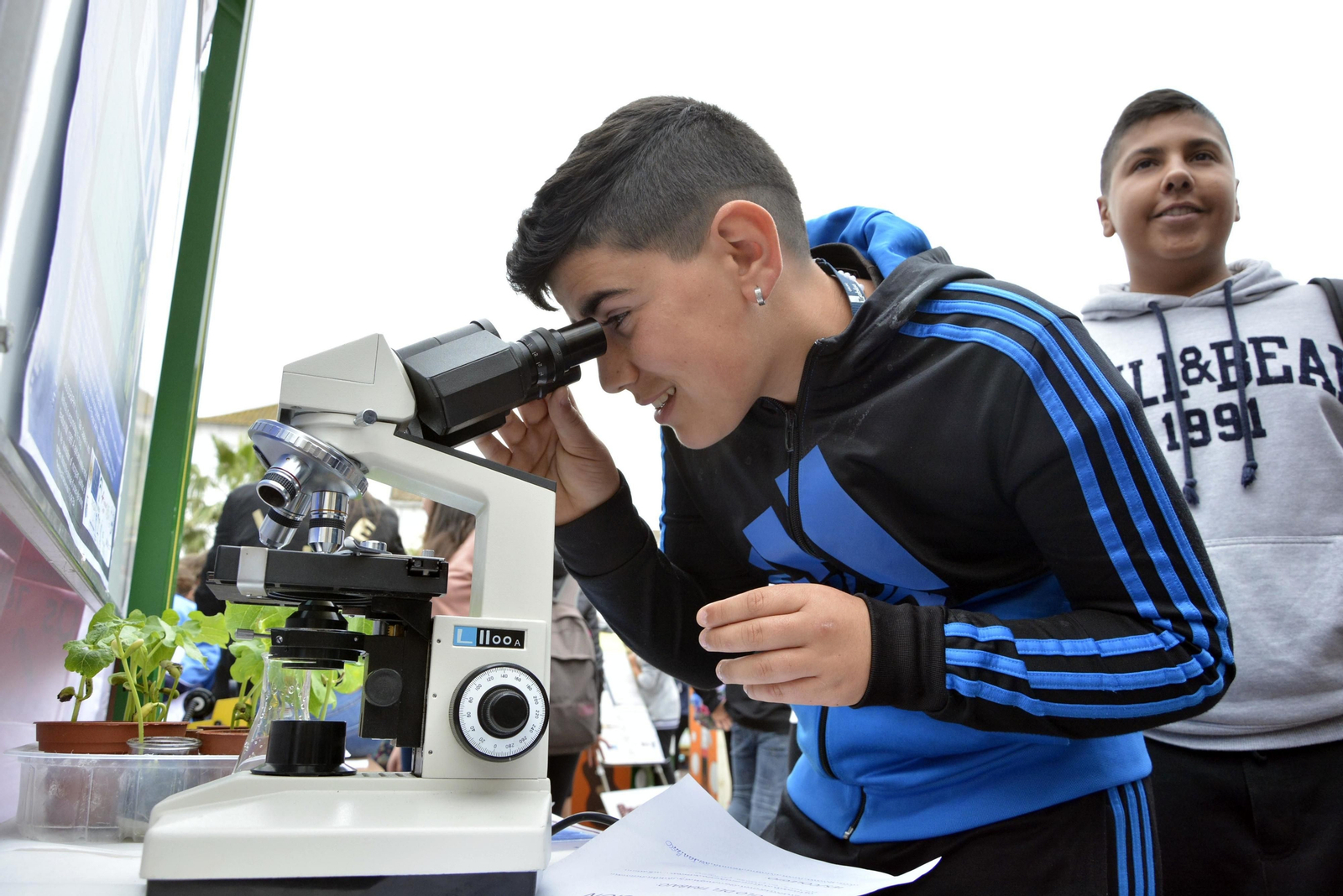 Un joven mira por un microscopio en las jornadas.
