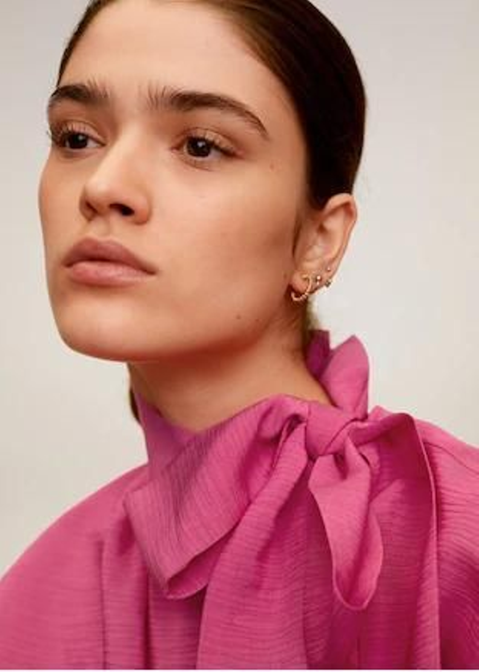 Detalle del cuello de la camisa rosa con lazo de Mango Outlet.