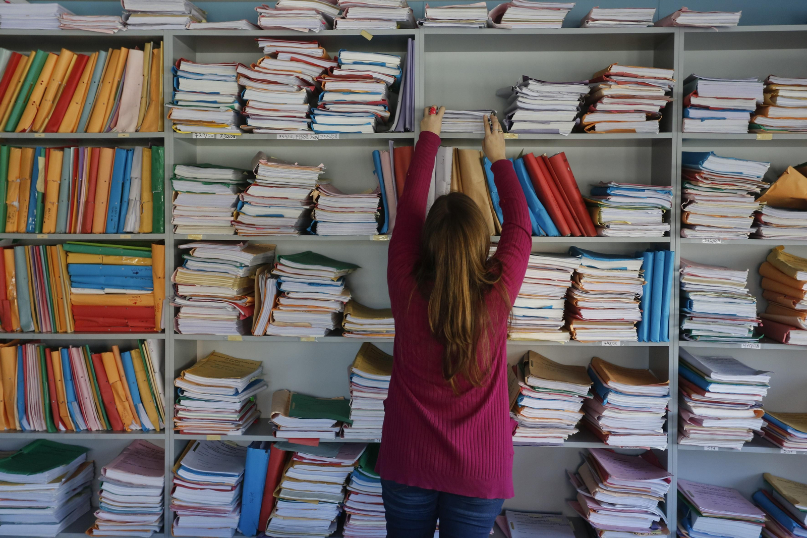 Interior de un juzgado con estanterías llenas de asuntos.