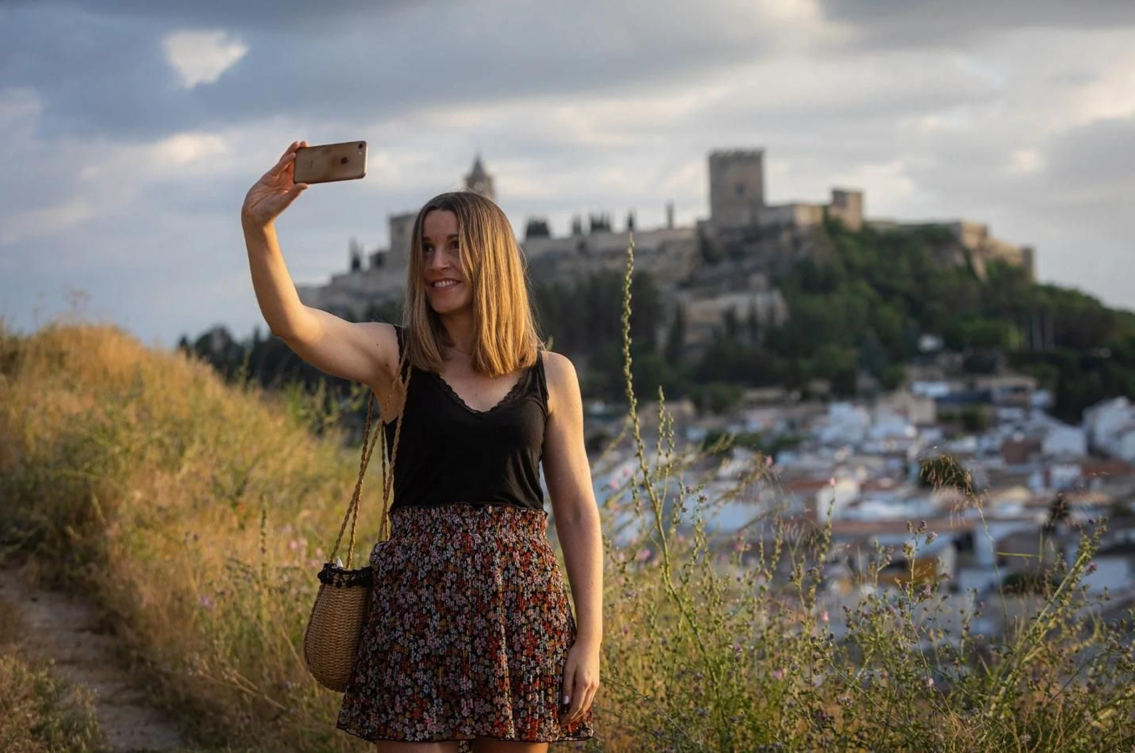 Una turista se toma una foto con la imponente Fortaleza de la Mota de fondo.
