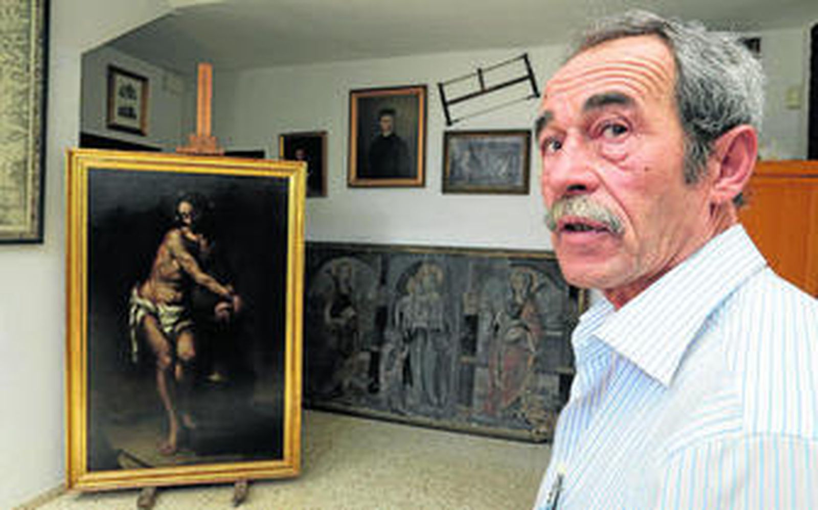 El restaurador sevillano Juan Luis Coto, ayer en su estudio de Dos Hermanas junto a la obra que ha intervenido.