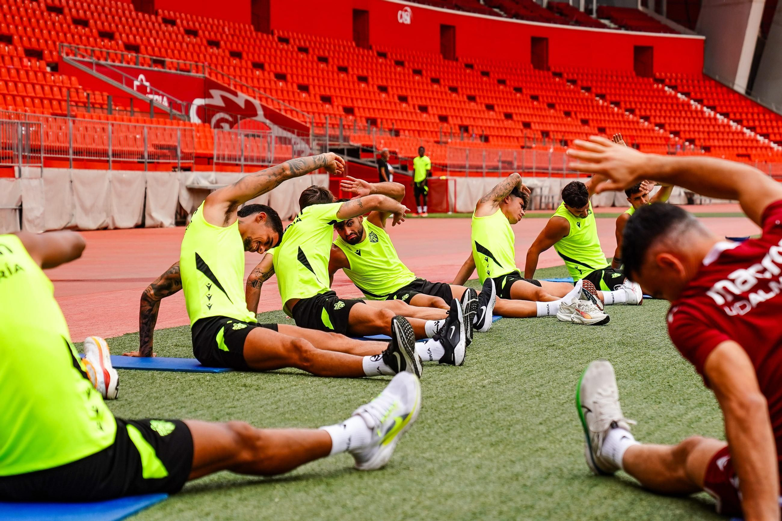 Los jugadores que contaron con minutos en el encuentro del pasado domingo realizan estiramientos durante el entrenamiento de este lunes.