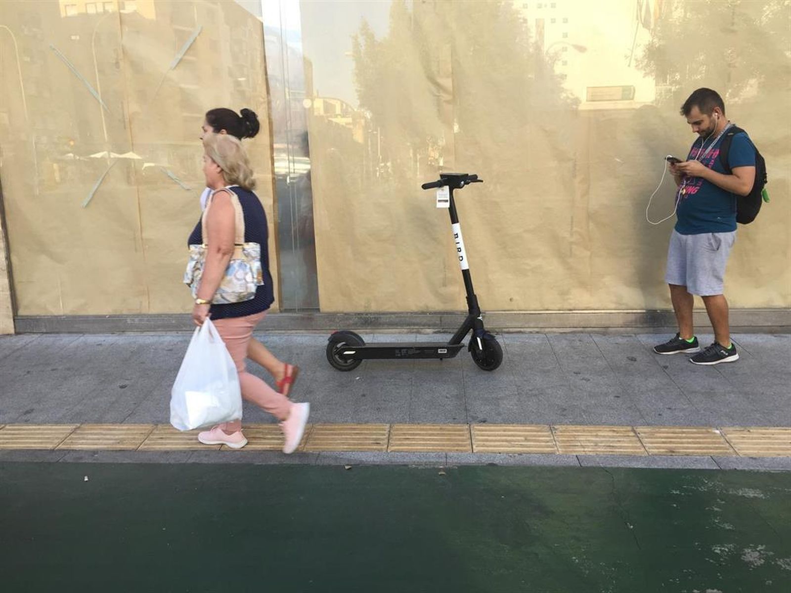 Un patinete aparcado al lado de un carril bici.
