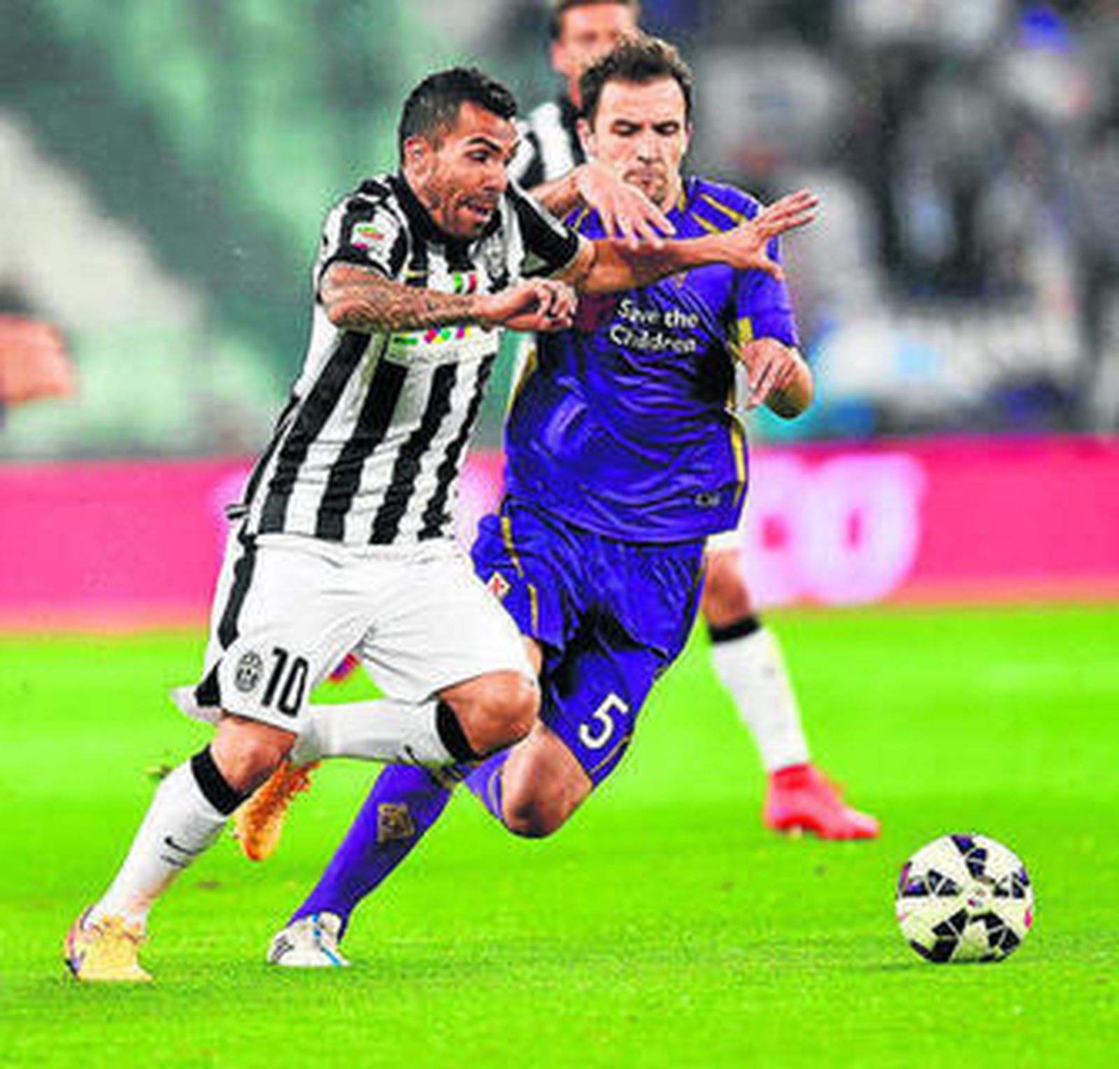 Tévez intenta zafarse con potencia de la marca de Badelj.