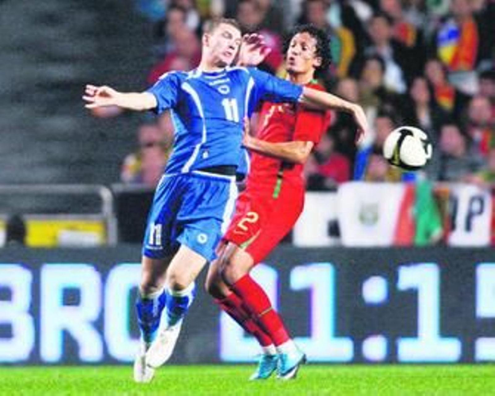 Dzeko pelea por el balón con el autor del gol de Portugal, Bruno Alves.