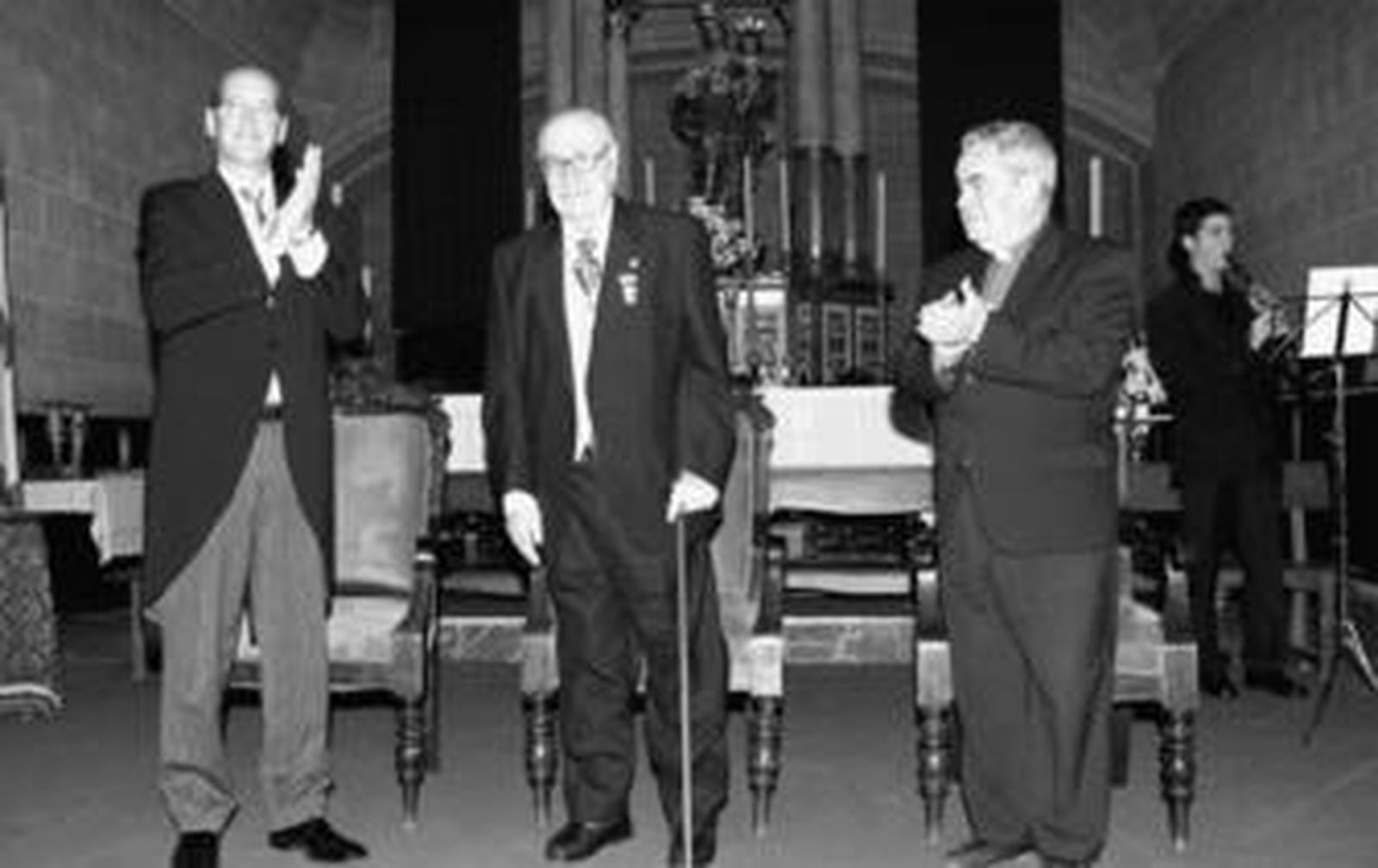 El alcalde de Moguer, Juan José Volante; y el párroco, Manuel Bolaños, aplauden a Francisco Garfias tras recibir la Medalla.