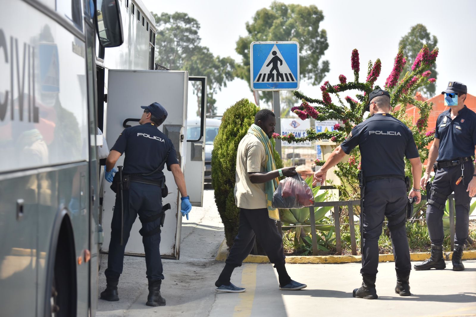 Uno de los inmigrantes baja del autobús de la Guardia Civil.