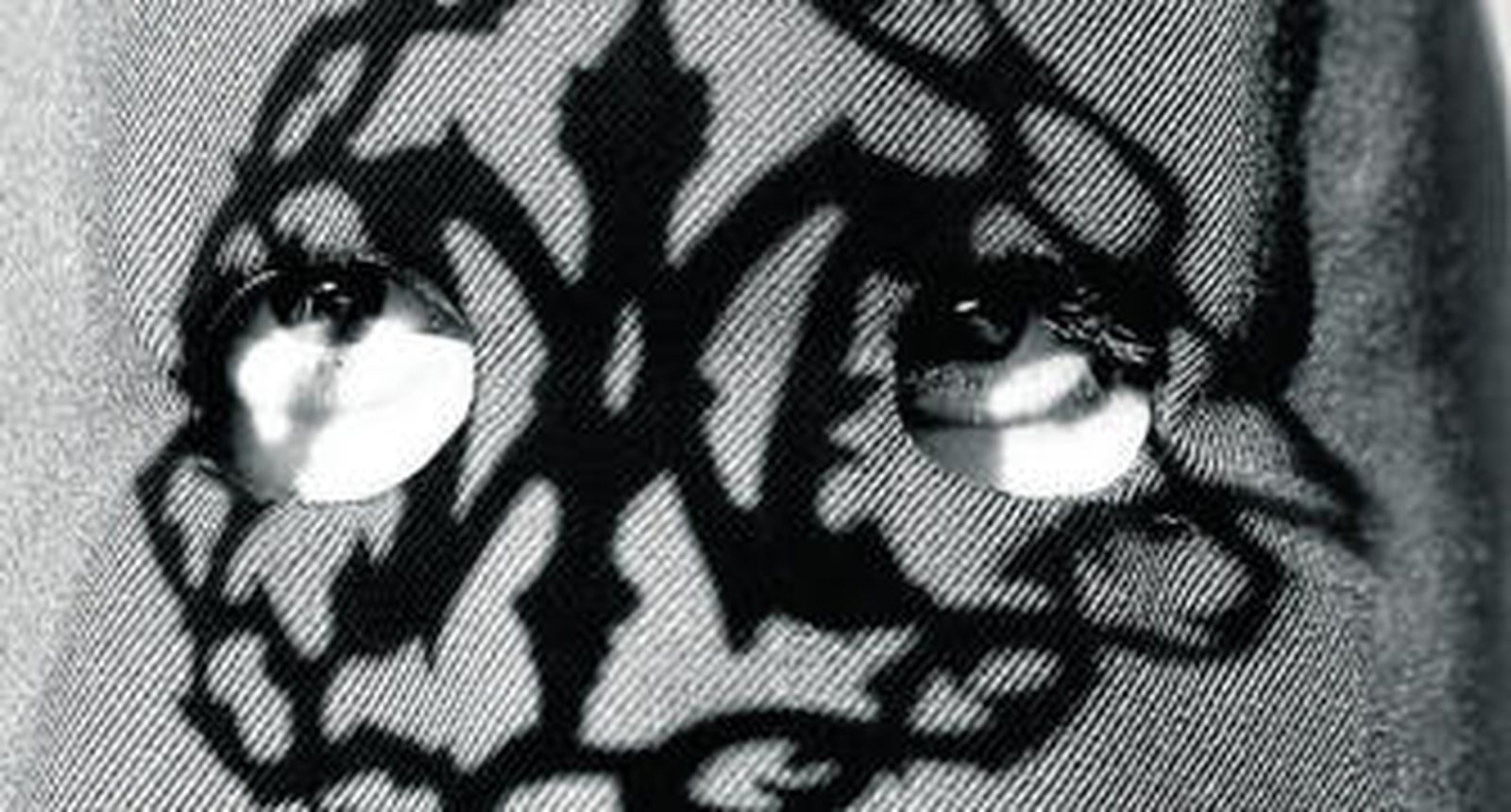 La mirada de un hermano de la Redención, con la sombra del escudo de la vara proyectado en el antifaz.