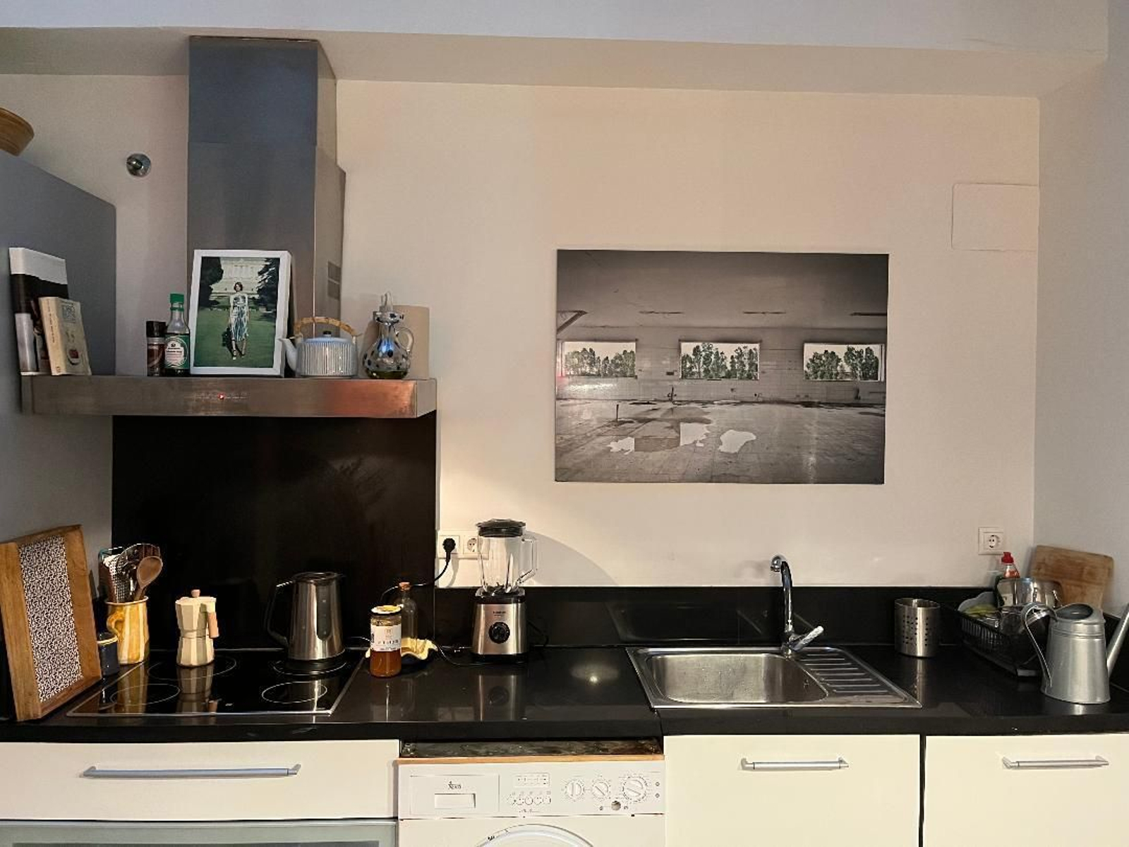 Mobiliario blanco de diseño italiano combinado con una encimera negra, en la cocina.