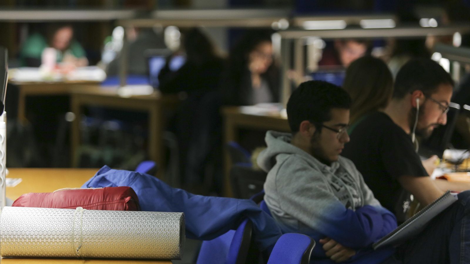 Sacos de dormir y mantas en las mesas junto a los alumnos.