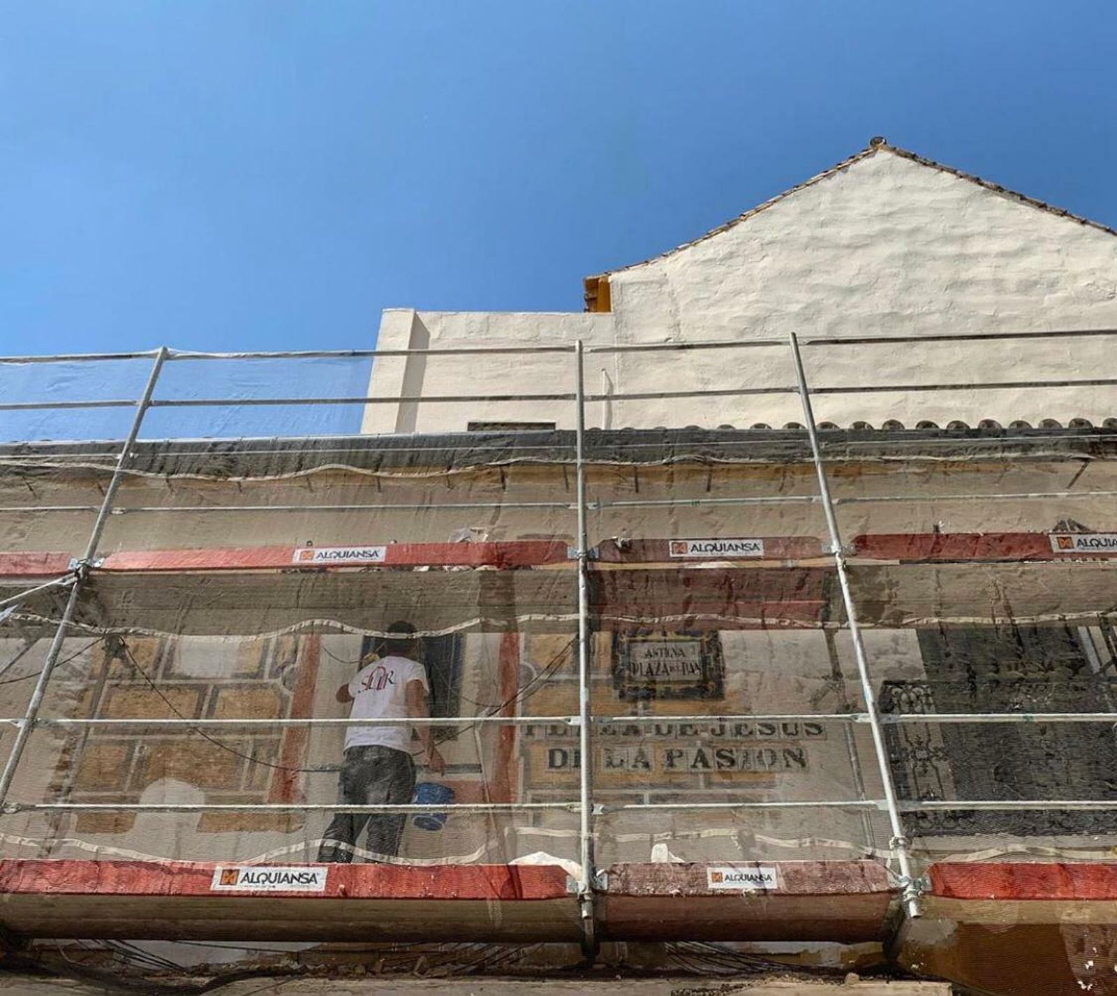 Detrás de los andamios se observa el esgrafiado que ha aparecido en la fachada de la casa rectoral del Salvador.