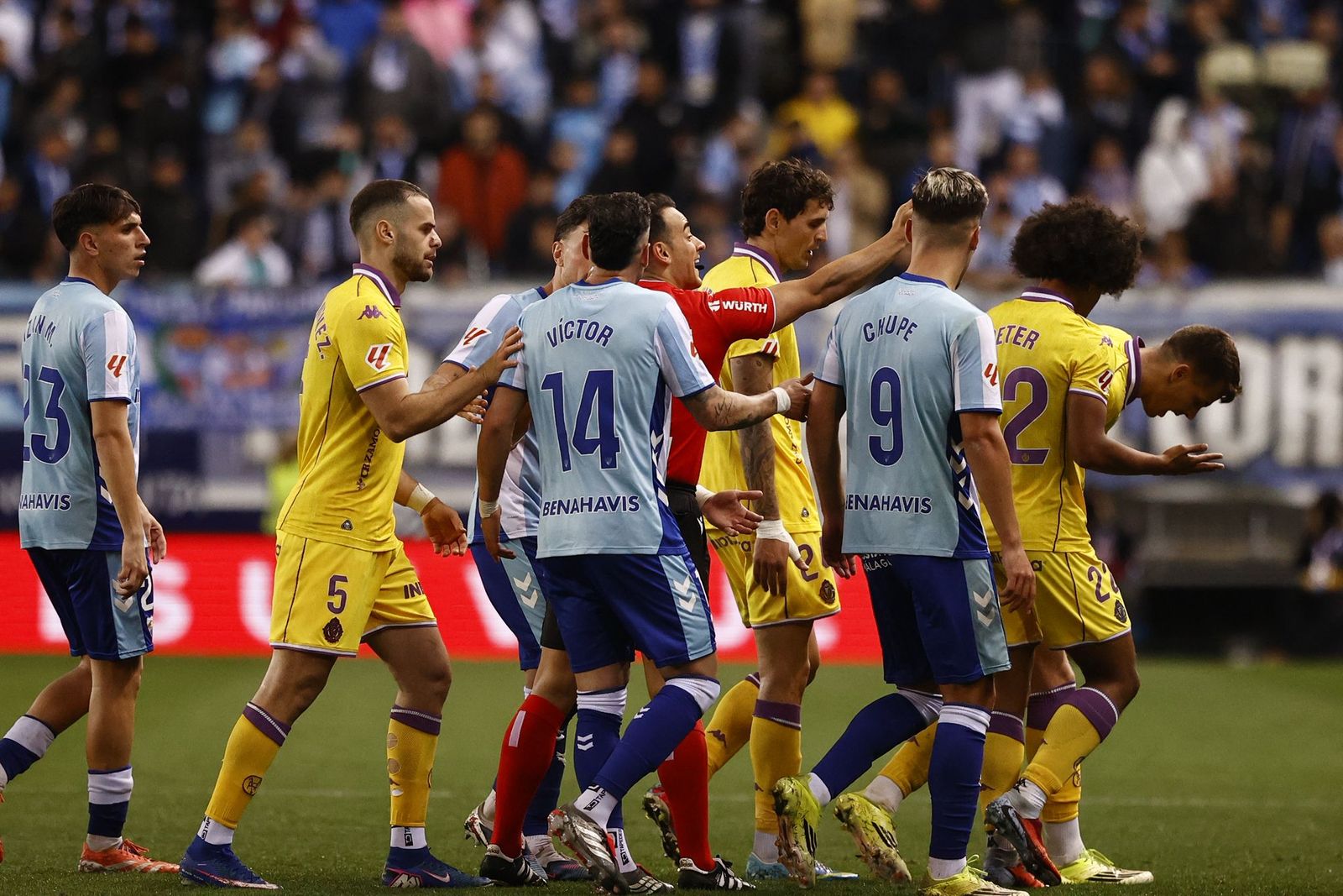 Los jugadores hablan con el árbitro del Málaga CF-Real Valladolid