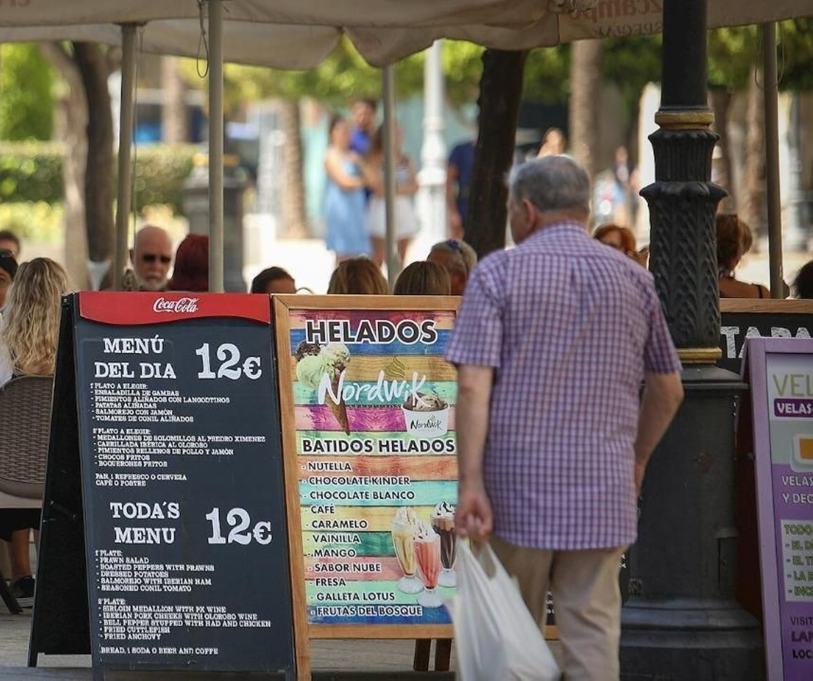Carteles en la terraza de un bar en el centro de Jerez.