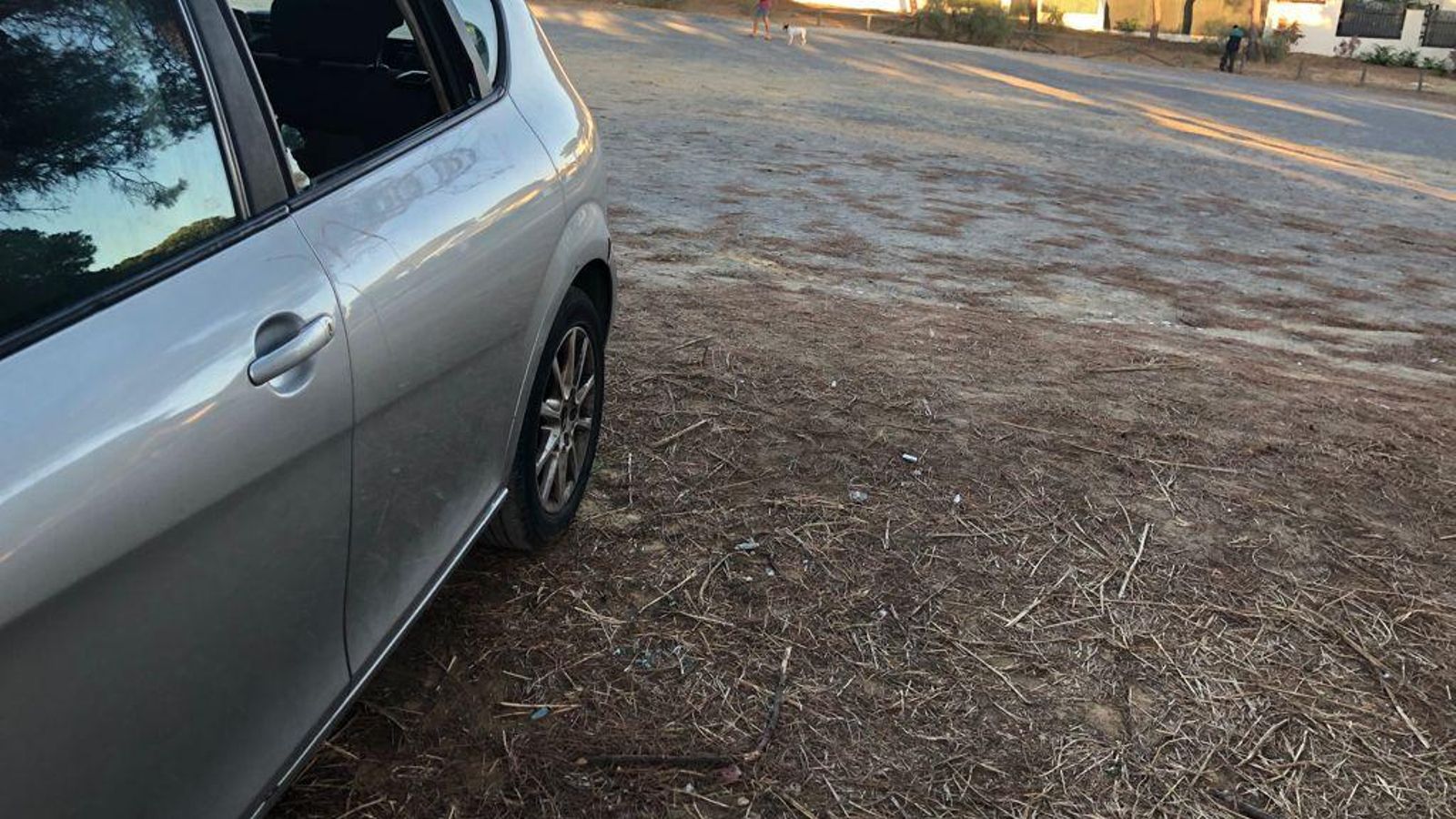 Luna trasera rota en uno de los vehículos estacionados en el descampado regulado como Zona Roja ORA de Punta Umbría.