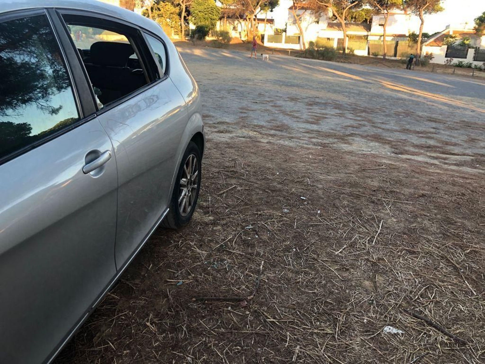 Luna trasera rota en uno de los vehículos estacionados en el descampado regulado como Zona Roja ORA de Punta Umbría.