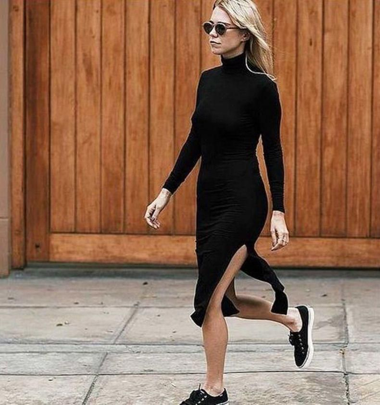 Look con vestido negro de punto y zapatillas deportivas.