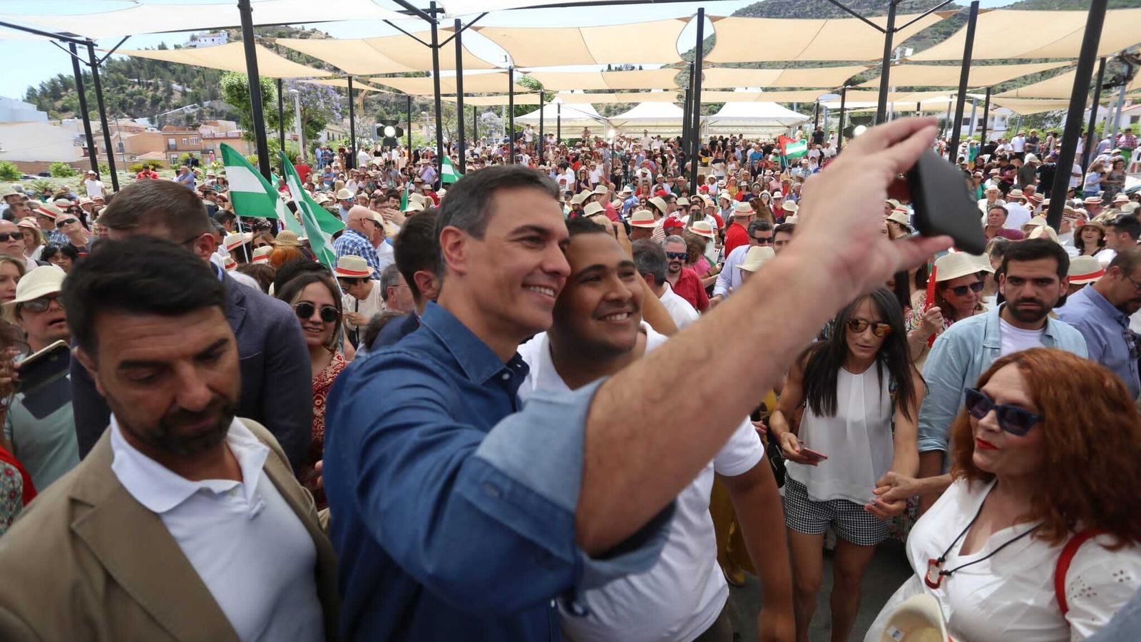 Pedro Sánchez haciéndose una foto con un asistente al acto.