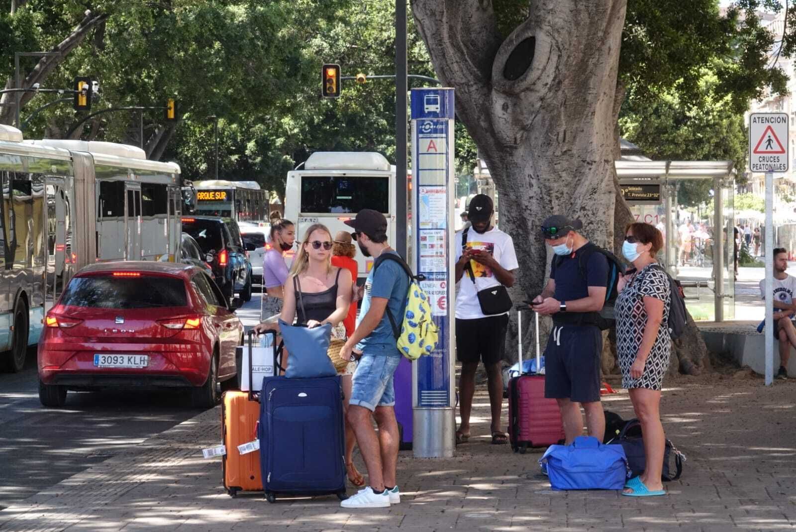 Turistas en una parada de autobús en Málaga.