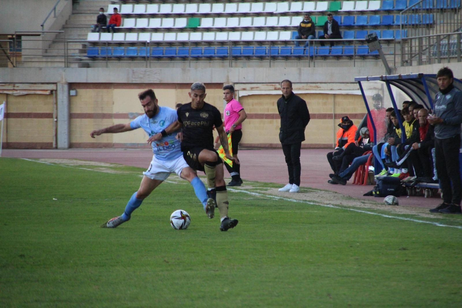 Fran Alcoy, al fondo, observa una jugada en el partido de este domingo.
