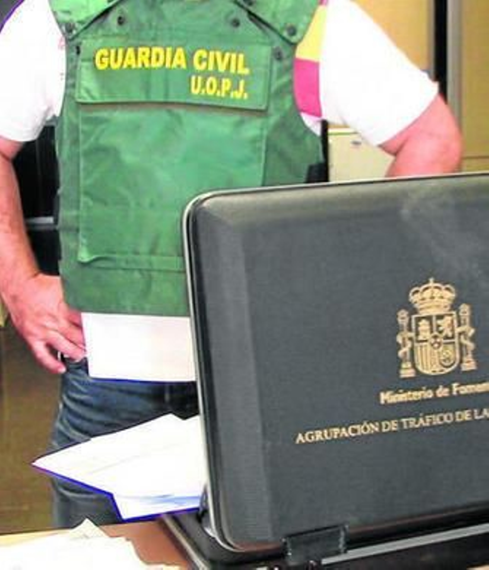 Un agente con parte de los documentos intervenidos.