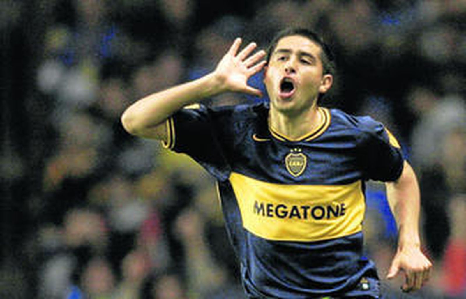 Juan Román Riquelme, celebrando un gol con la elástica bostera y su gesto característico.