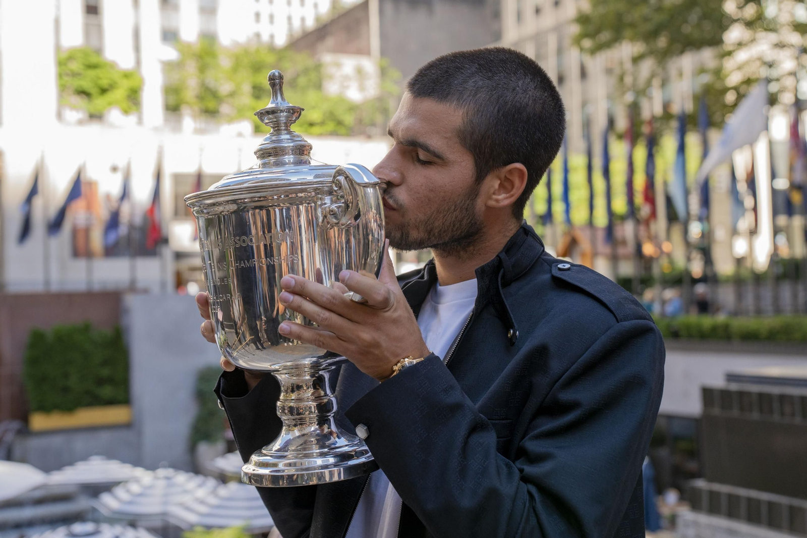 Carlos Alcaraz besa la copa de ganador del US Open durante la sesión de fotos oficial.