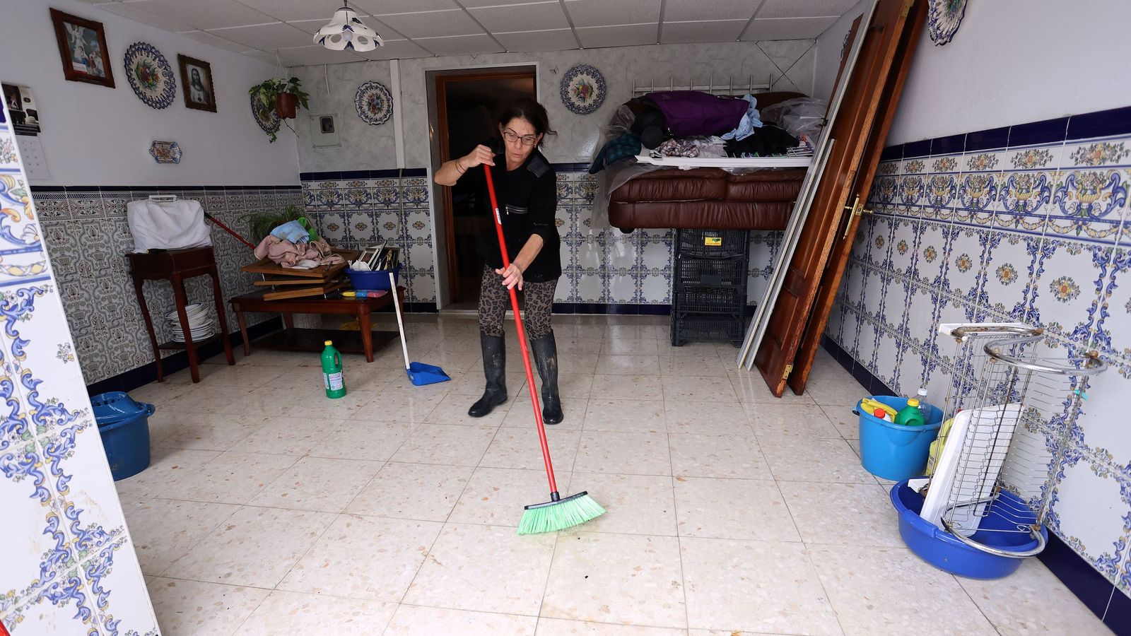 Una vecina de El Portal limpia una de las viviendas afectadas por la crecida del río Guadalete en Jerez.