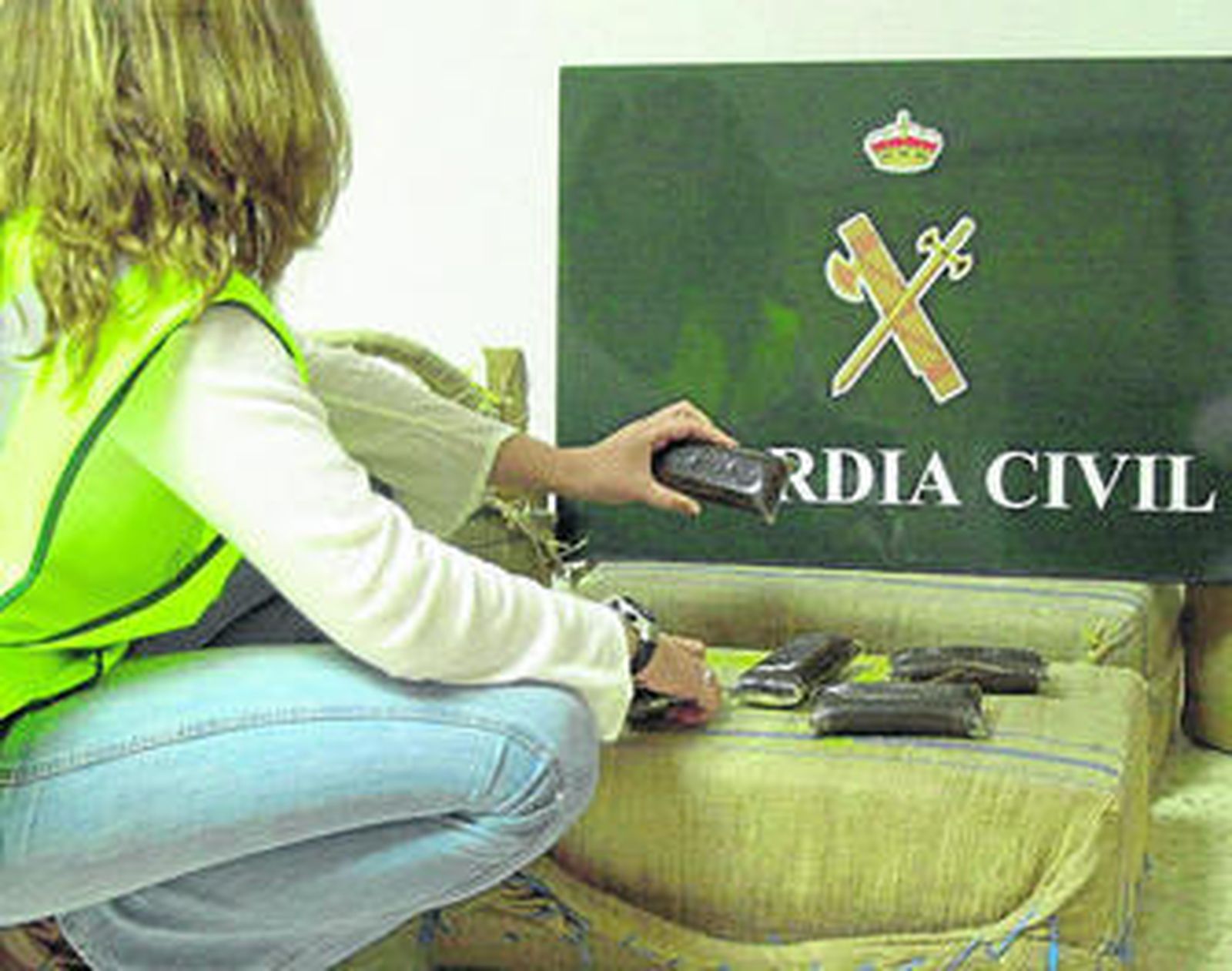 Emblema de la Guardia Civil junto al hachís decomisado durante una operación antidroga.