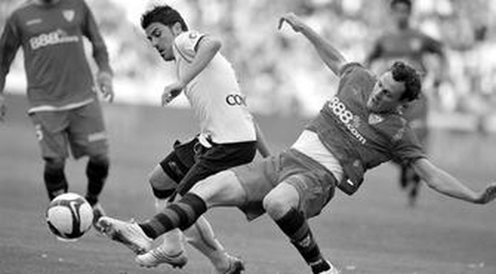 David Villa intenta alcanzar el balón en puja con el defensa sevillista Squillaci.