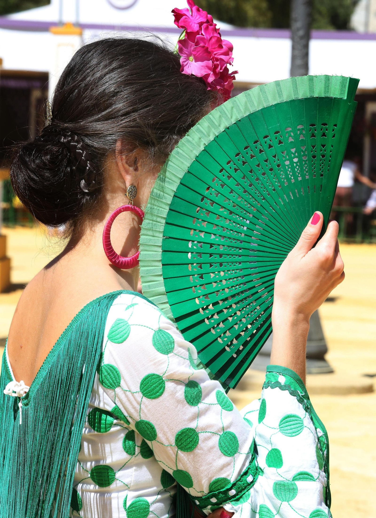 Una joven se protege del sol con su abanico.