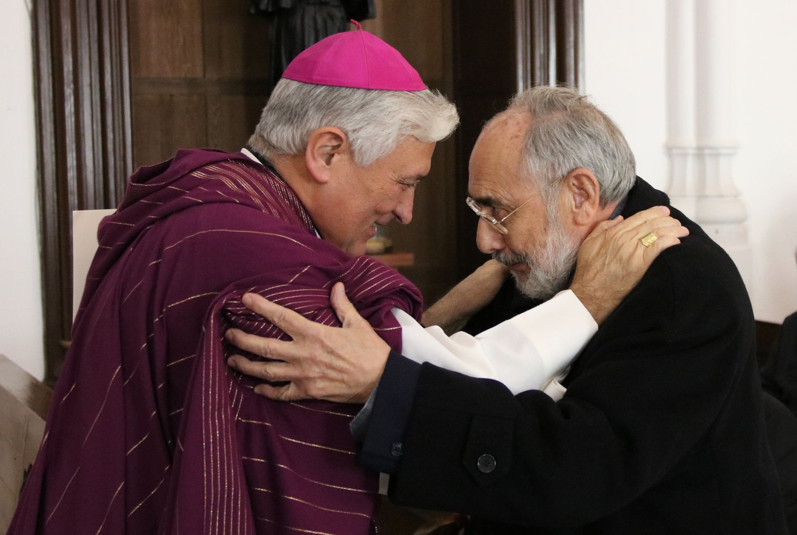 El obispo Rafael Zornoza y el canónigo José Carlos Muñoz se saludan.