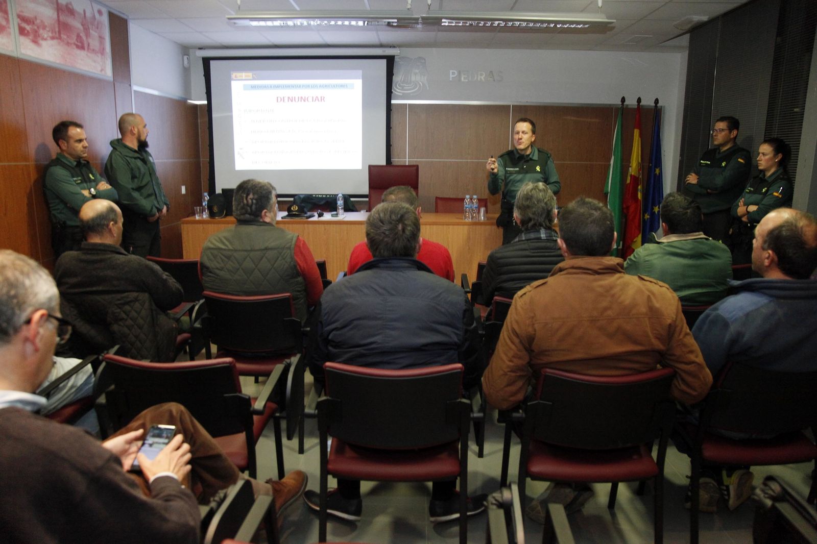 Un agente de la Guardia Civil habla a los agricultores y regantes en una actividad formativa y preventiva.