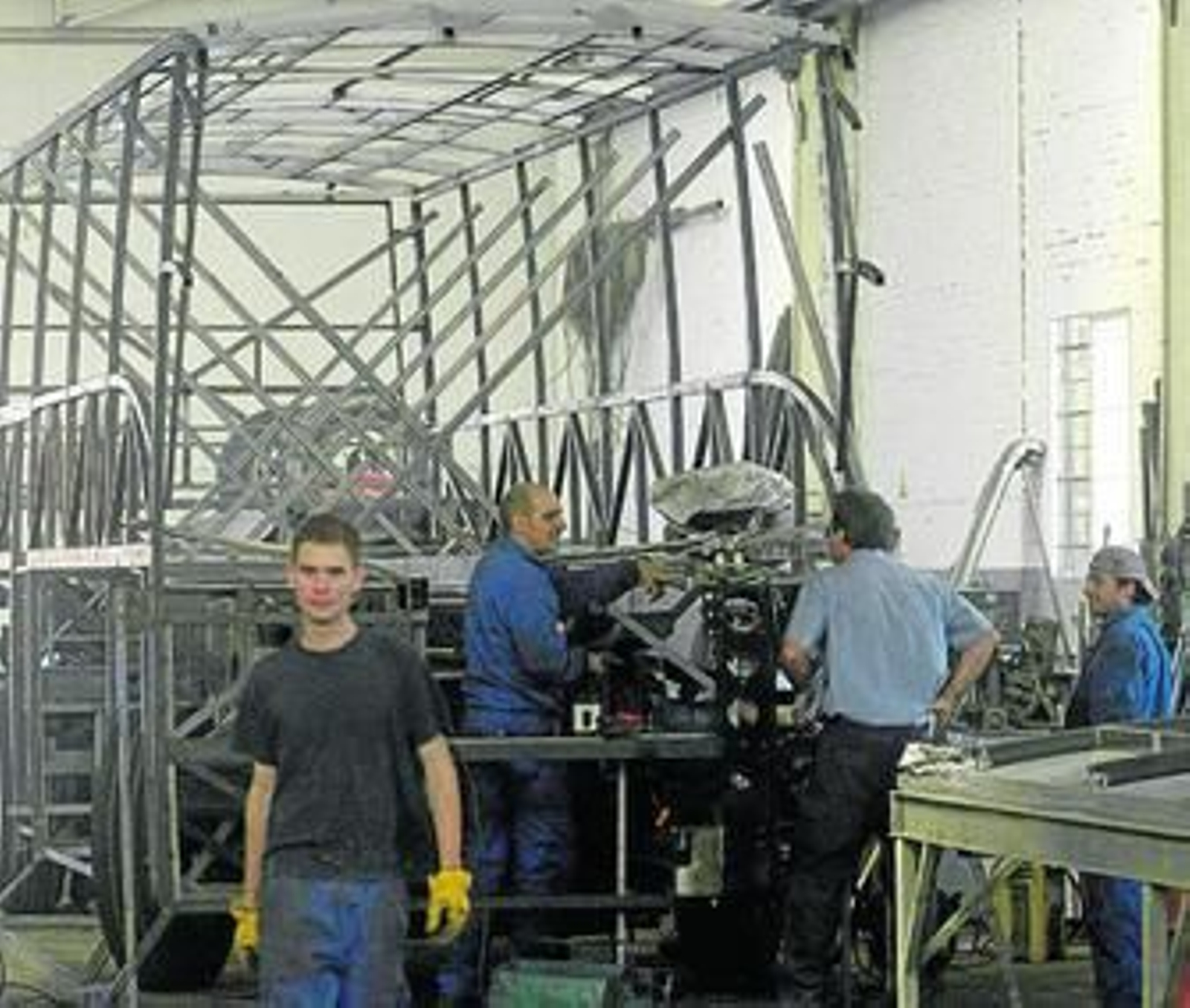 Operarios trabajan en el proceso de ensamblaje de una carrocería.