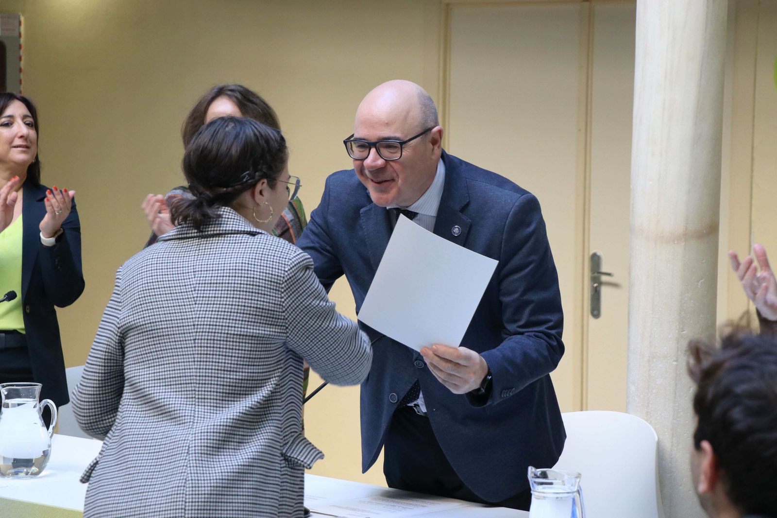 El rector entrega el galardón a una de las premiadas.