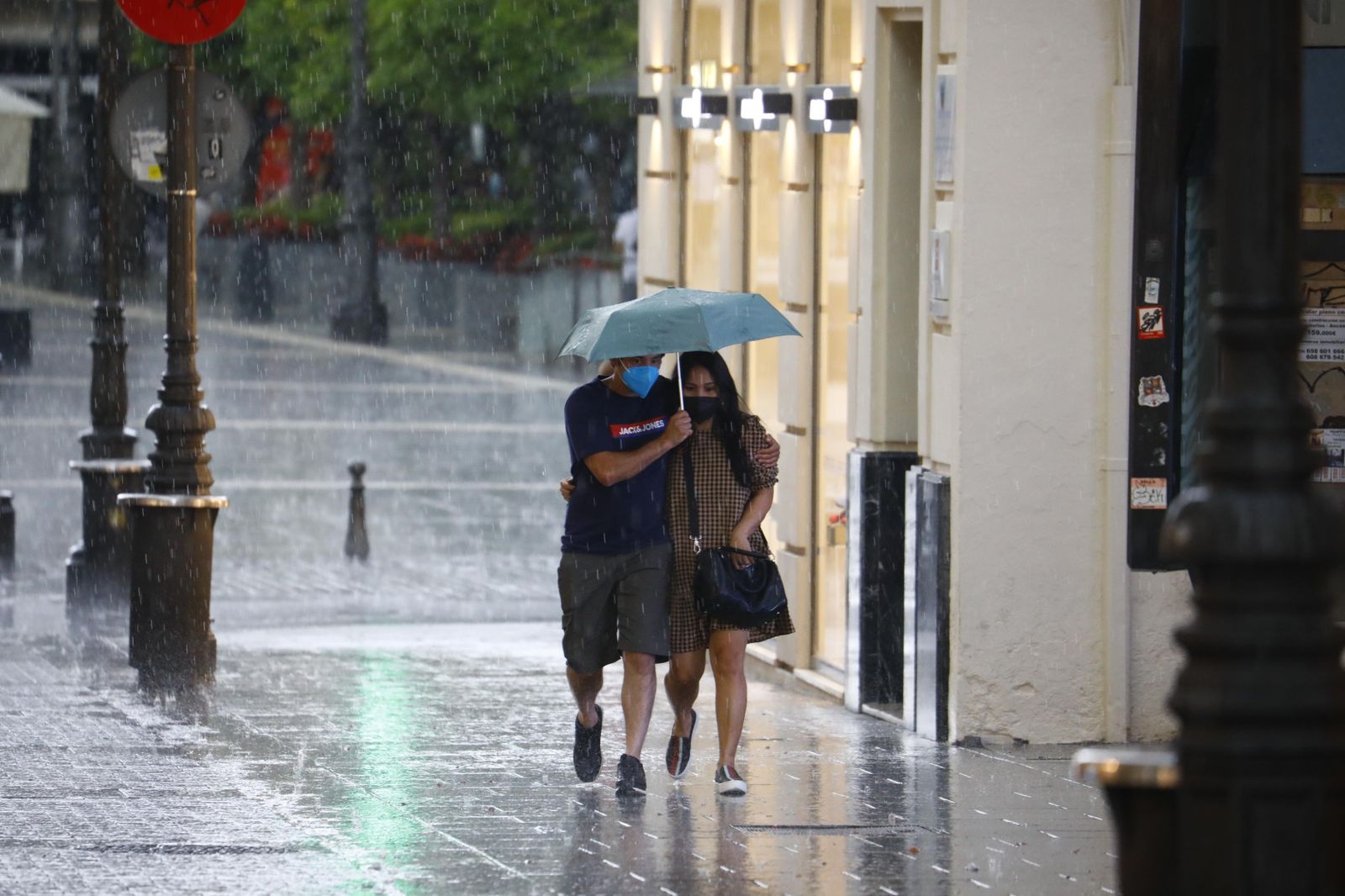 Dos jóvenes pasean bajo la lluvia en Córdoba.