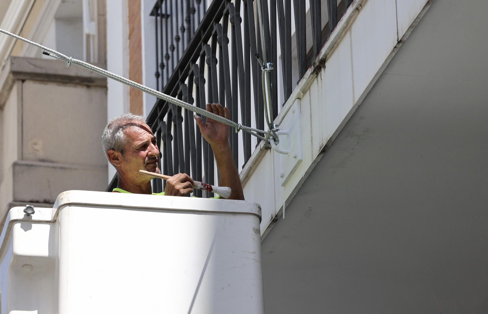Pintan las placas metálicas donde se enganchan los toldos de la Avenida