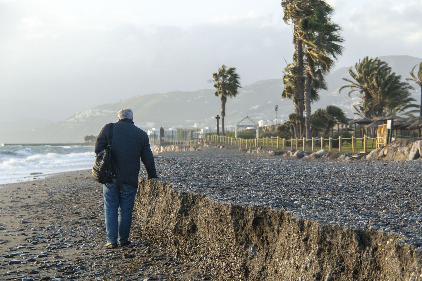 Un hombre pasea por Playa Granada tras el azote del último temporal.