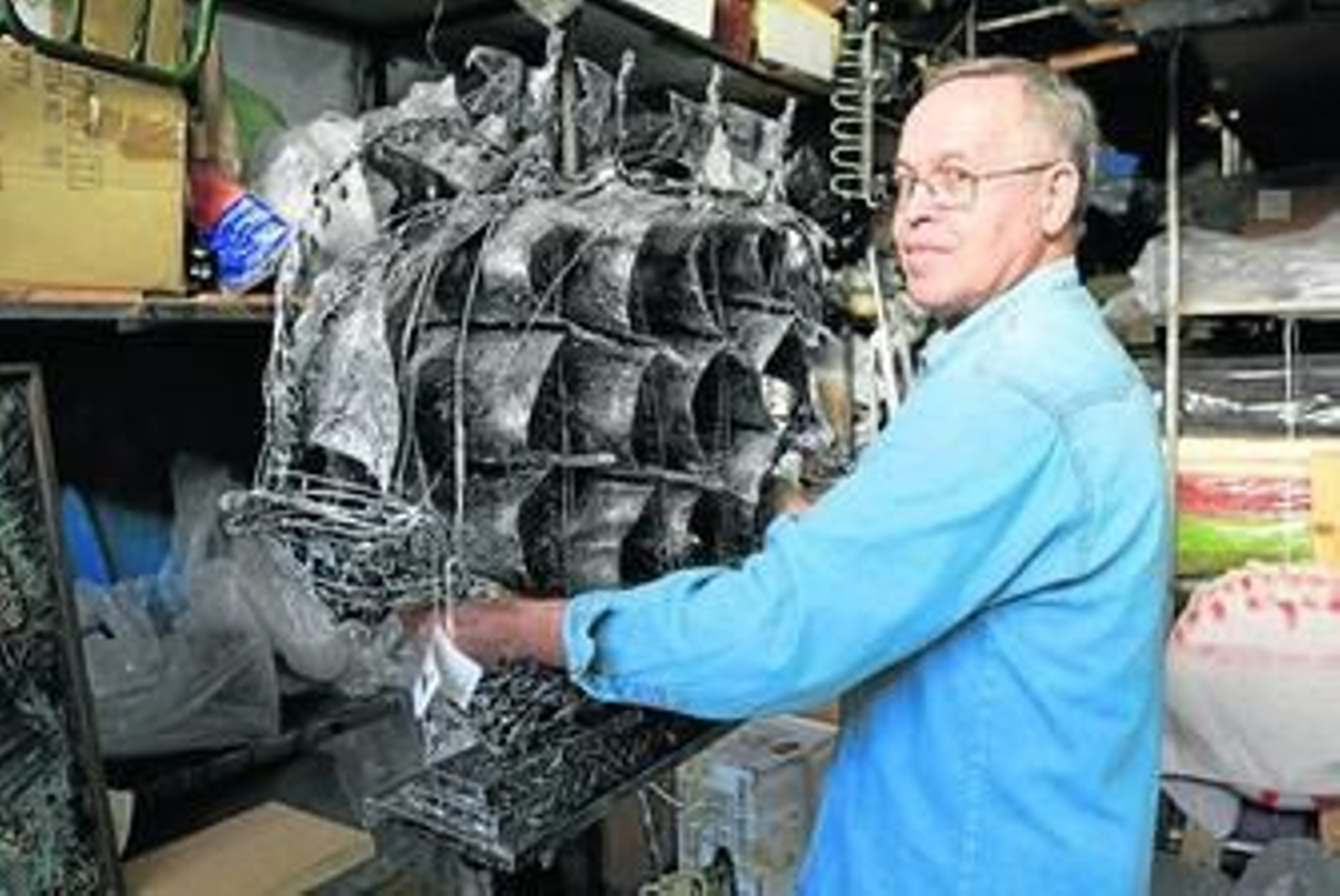 Martínez posa con la escultura de un barco impresionante.