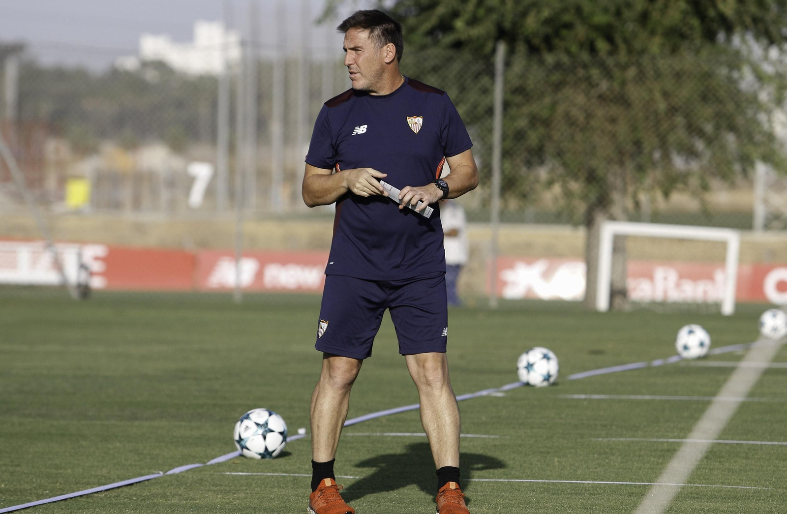 Eduardo Berizzo observa el entrenamiento con los balones de la Champions tras él.