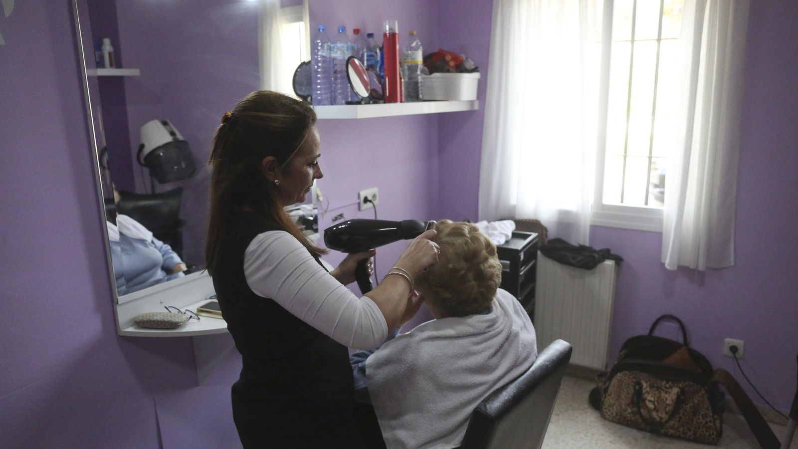 Pepa Sánchez peina a una usuaria.