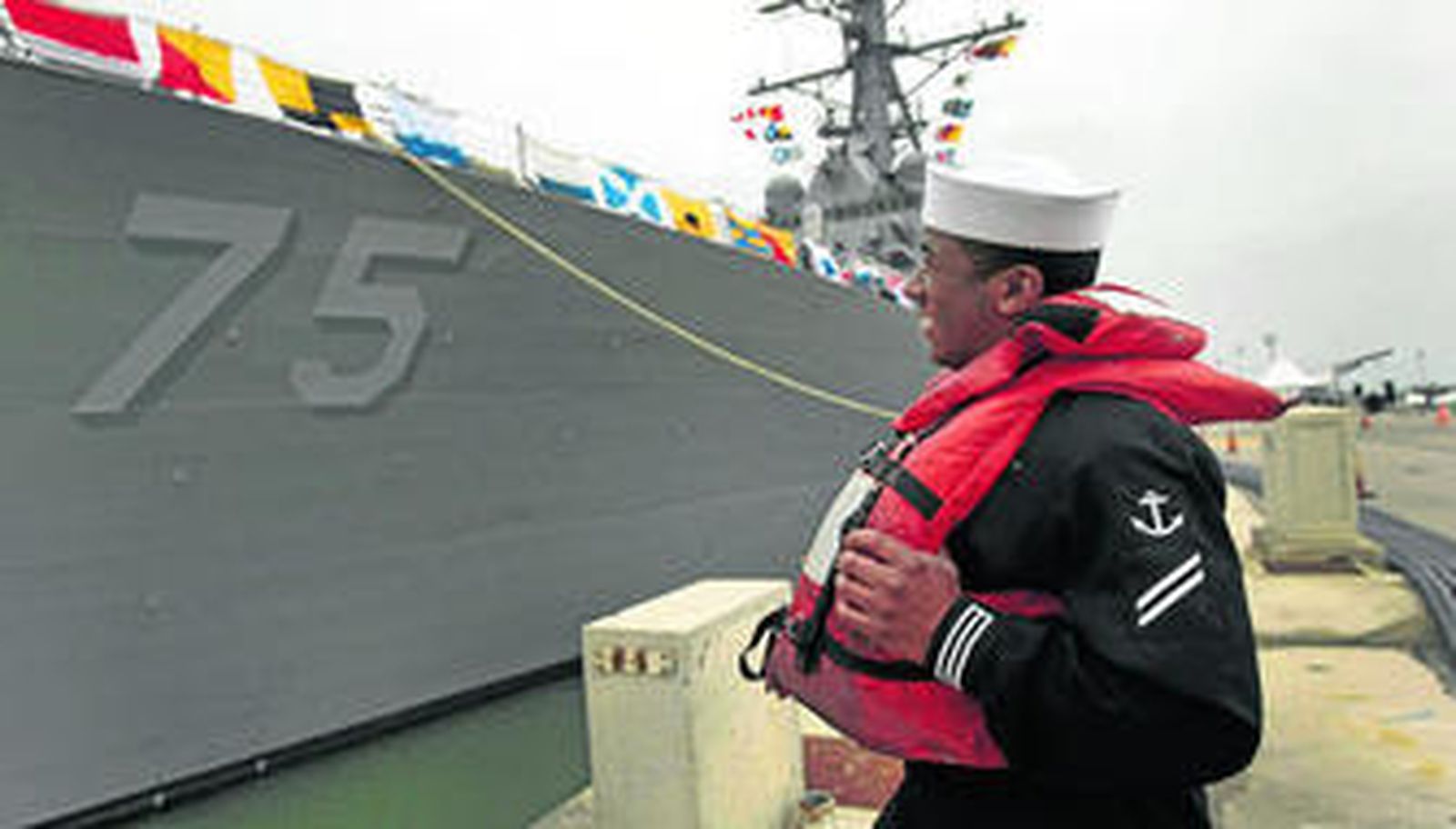 Un miembro de la tripulación del 'USS Donald Cook' observa el navío, ya atracado en la Base de Rota.